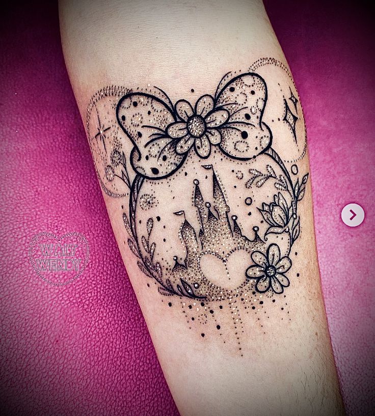 a black and white tattoo on the arm of a girl with a bow in her hair