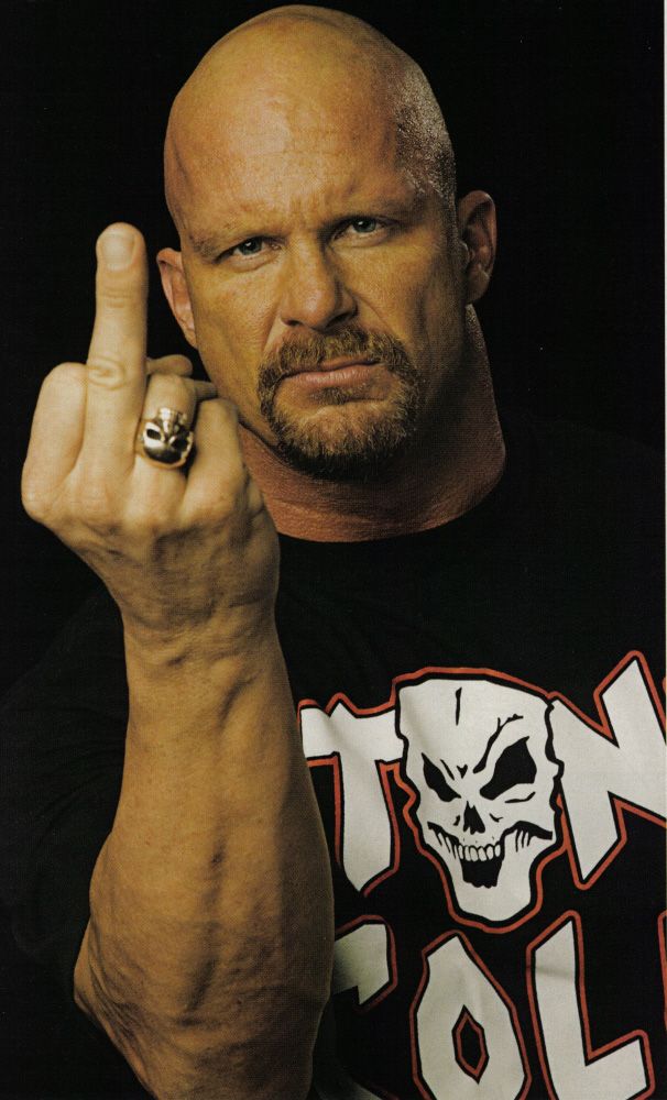 a bald man in a black shirt with a ring on his finger pointing at the camera