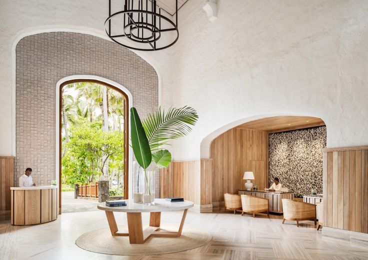 a room with a table, chairs and a potted plant in the middle of it