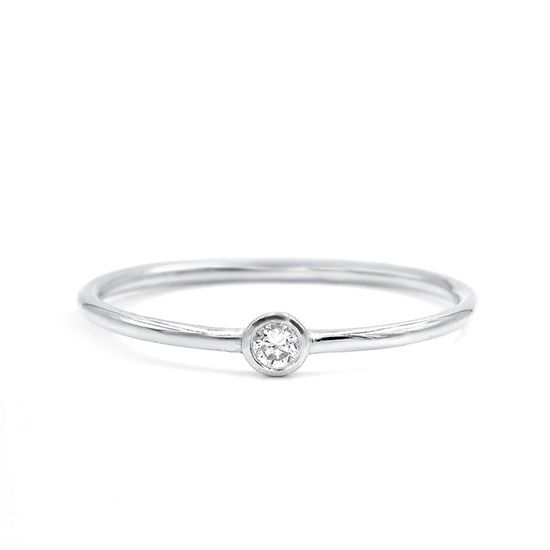 a white gold ring with a single diamond in the center, on a white background