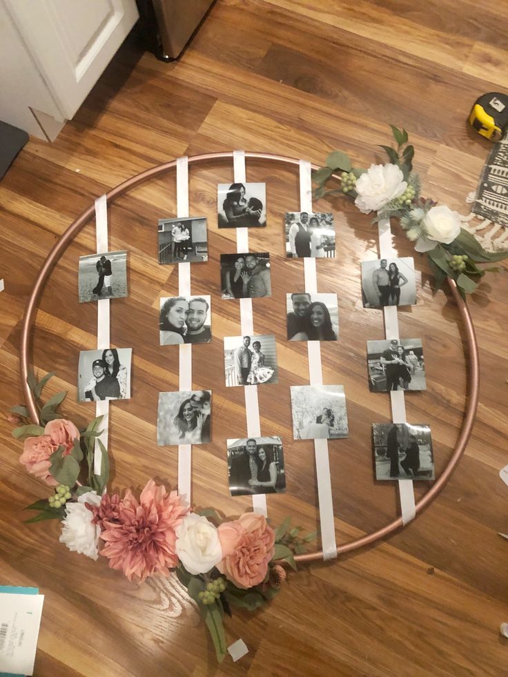 a round table topped with photos and flowers on top of a hard wood floor next to a laptop computer