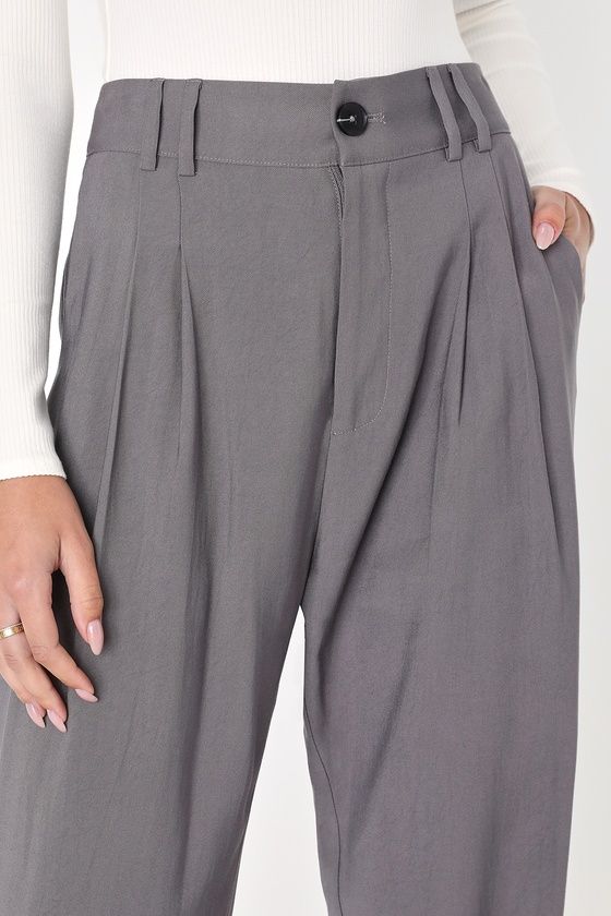 Per our last email, the Lulus Strictly Business Grey High-Waisted Trouser Pants are highly recommended for all boss babes! Lightweight woven twill creates a high waist (with a bit of elastic at the back), belt loops, and a brown marbled top button with a hidden zip fly. Pleated accents detail relaxed pant legs, with two diagonal pockets, that taper to ankle-length hems. Twin patch pockets at back. Fit: This garment fits true to size. Length: Ankle length. Size medium Inseam: 28.25 Front Rise: 13 Trendy Ankle-length Workwear Pants, Trendy Workwear Bottoms With Elastic Waistband, Chic Solid Color Tapered Leg Bottoms, Chic Cotton Straight Work Pants, Trendy Tapered Leg Dress Pants For Business Casual, Solid Cotton Bottoms For Workwear, Trendy Workwear Bottoms, Chic Cotton Work Trousers, Trendy Business Casual Bottoms With Elastic Waistband