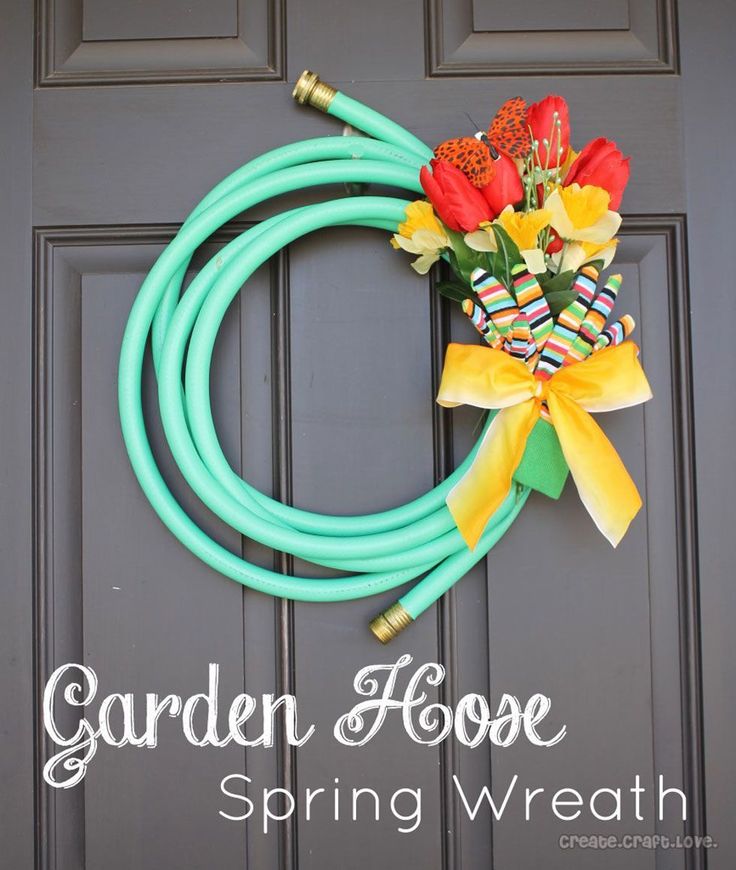 the front door is decorated with flowers and hoses for garden hose wreath decorating