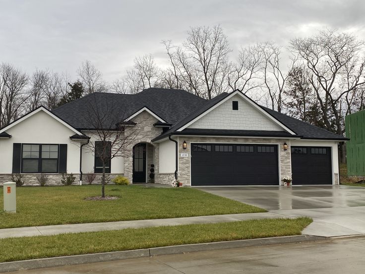 a white and black house with two garages