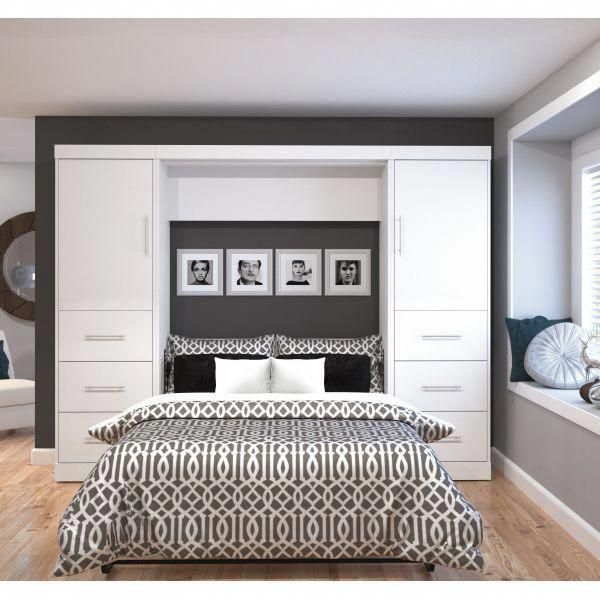 a bedroom with white and black bedding, drawers, and pictures on the wall