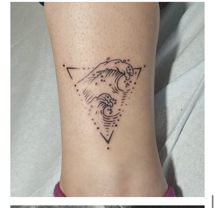 a woman's foot with a small tattoo on the side of her leg and an arrow in the middle