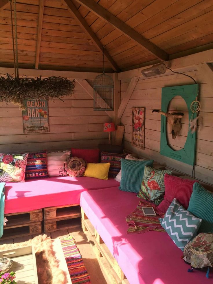 a pink couch sitting under a wooden roof