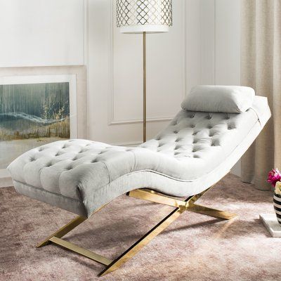 a white chaise lounge chair sitting on top of a carpeted floor next to a lamp