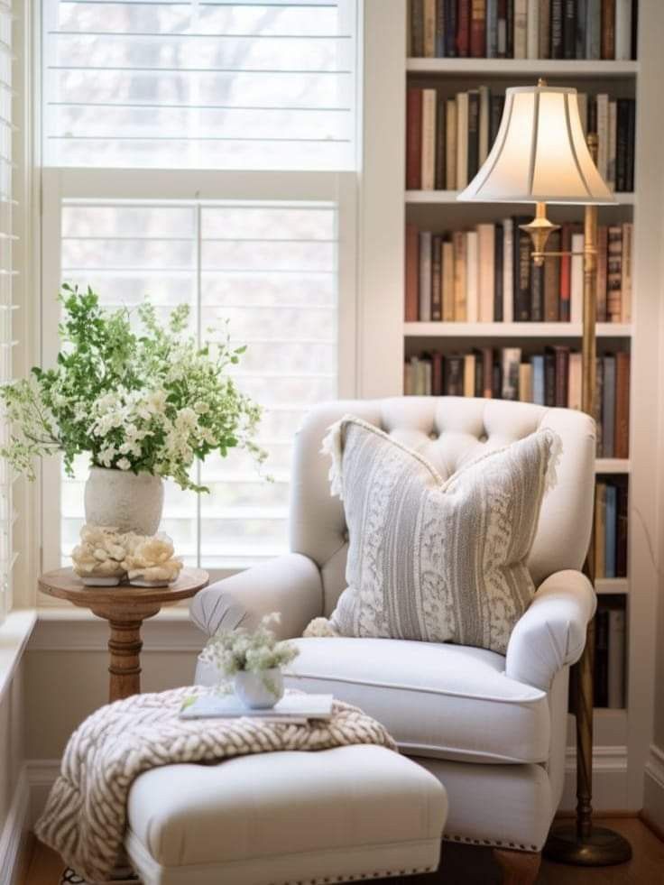 a white chair and ottoman in front of a window