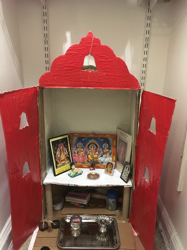 a small shrine in the corner of a room that has been painted red and white