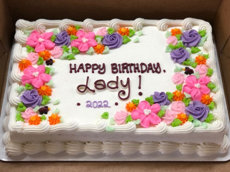 a birthday cake with flowers on it in a box