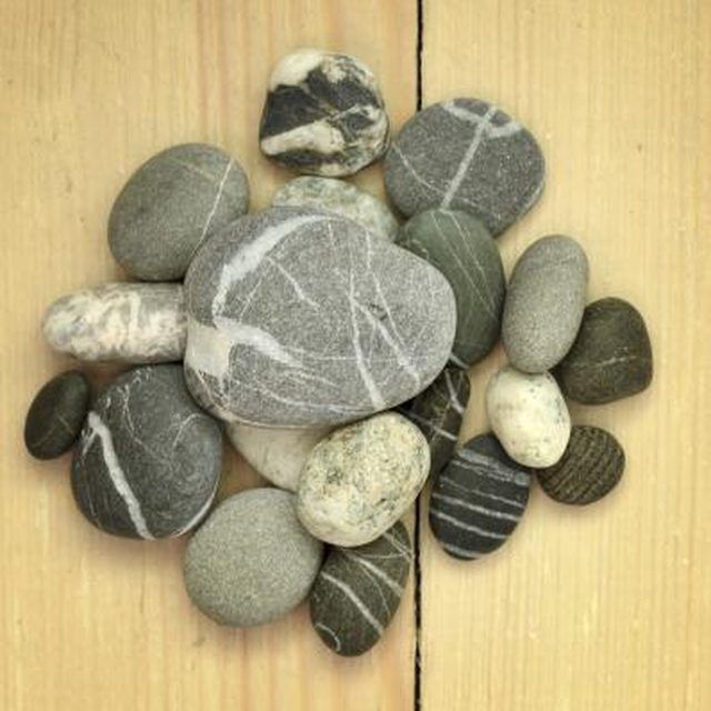 a bunch of rocks sitting on top of a wooden table next to each other in the shape of a flower