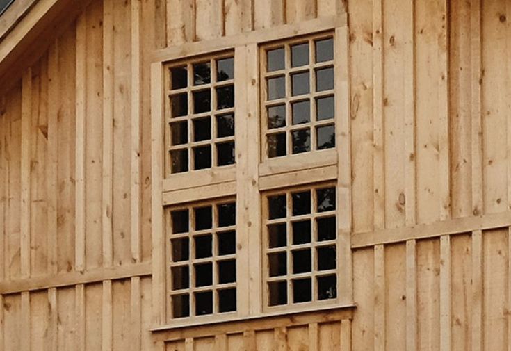 a large wooden building with three windows on each side