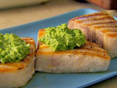 three pieces of meat with guacamole on top sitting on a blue plate