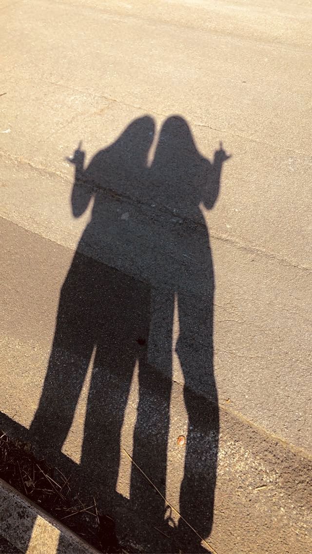 the shadow of two people standing next to each other