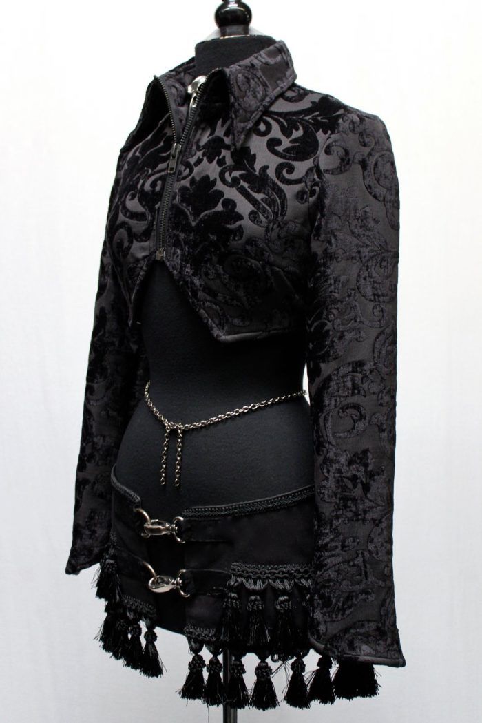 A jacket with a hauntingly dark style! A stylish women's crop jacket made in luxurious black velvet fabric with an ornate swirling design on it. The jacket has a high pointed collar and zips in front with a blackened gunmetal zipper. The sleeves are tapered and have a pointy bell shaped cuff. In back the jacket has a fancy duck tail that is split in the middle. So much style! Comes in sizes Small-XXL. Sizes: Small - Chest 34" Shoulders ( shoulder seam to shoulder seam across upper back) 14.5" Me Gothic Long Sleeve Velvet Outerwear, Black Velvet Costume Outerwear, Gothic Fitted Velvet Outerwear, Black Gothic Velvet Outerwear, Fitted Gothic Velvet Outerwear, Black Velvet Gothic Outerwear, Womens Cropped Jacket, Black Velvet Fabric, Printed Velvet