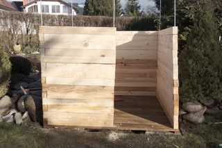 a wooden box sitting in the middle of a yard