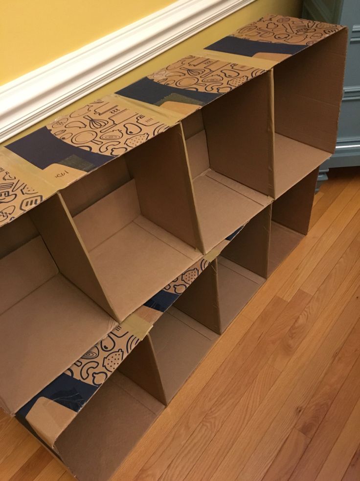 cardboard boxes are stacked on top of each other in the middle of a wooden floor