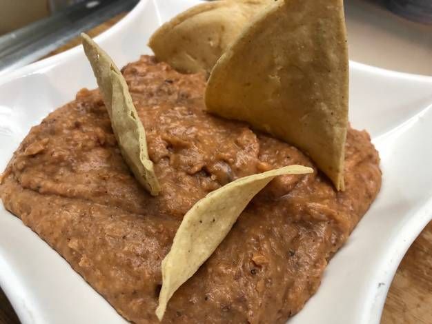 a white plate topped with tortilla chips and guacamole