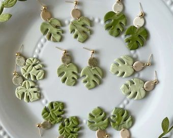 a white plate topped with lots of green leaf earrings