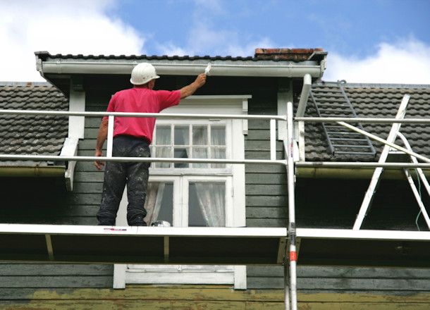 a man is painting the roof of a house