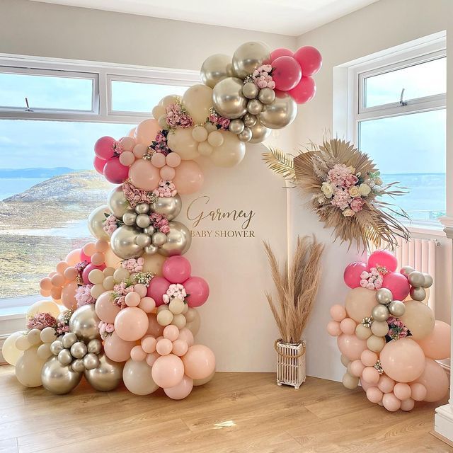 the balloon arch is decorated with pink, gold and silver balloons