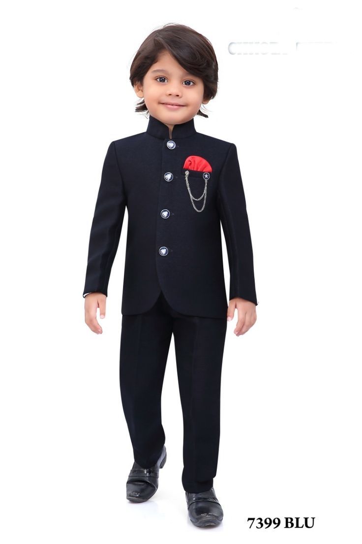 a young boy wearing a black suit and tie with a red flower on the lapel