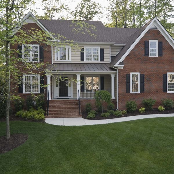 a brick house with black shutters and white trim