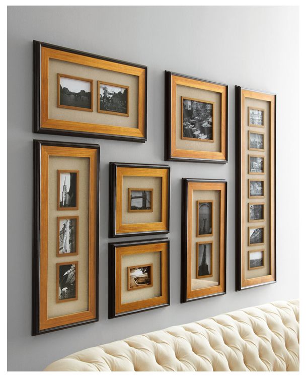 a white couch sitting in front of a wall with framed pictures on it's sides