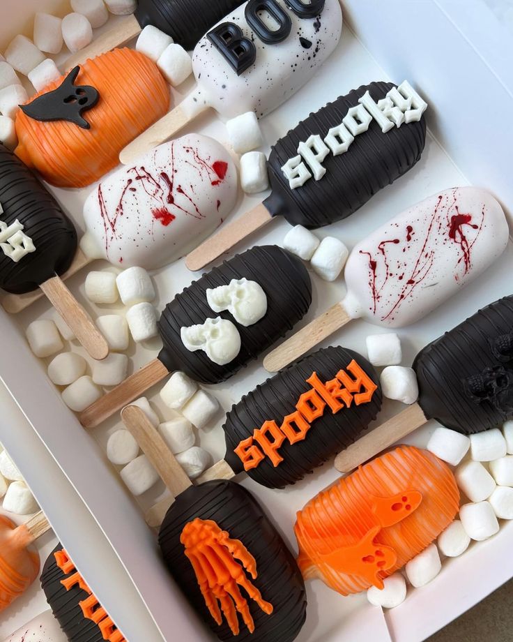 there are many halloween treats in the box on the table, including marshmallows and candy