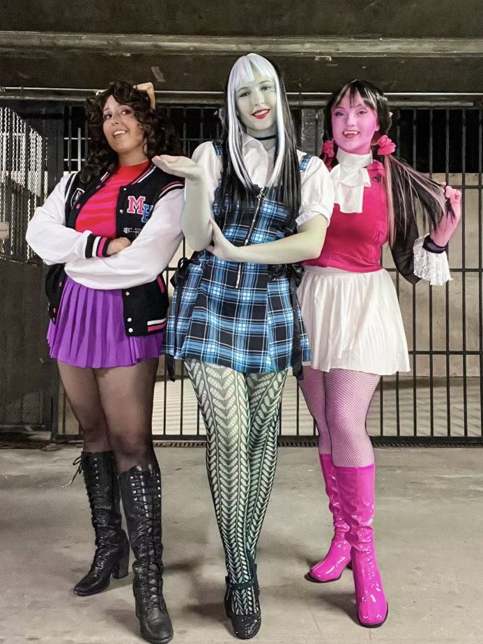 three women dressed in costumes standing next to each other