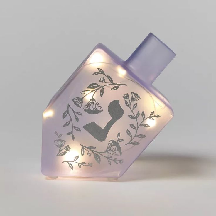 a bottle with some lights on it and a light up lid in the shape of a house