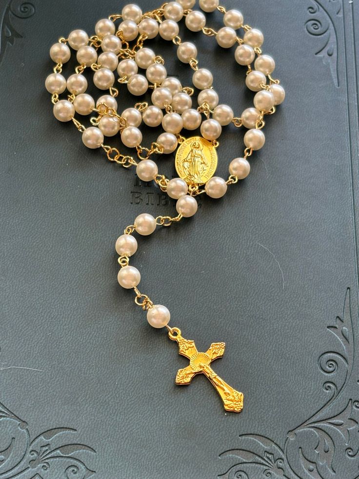 Beautiful handmade rosary that will make a wonderful addition to your prayer life. This rosary is made with gold colored wire and has a miraculous medal cemetery. Makes a great gift for religious ceremonies and holidays! Pearl Rosary With 8mm Beads As Gift, Gold Spiritual Rosary Bracelet For Wedding, Spiritual Wedding Miraculous Medal Jewelry, Spiritual Wire Wrapped Rosary As Gift, Spiritual Gold Rosary Bracelet For First Communion, Pearl Rosary With Round Beads As Gift, Gold Cross Rosary In Spiritual Style, Spiritual Pearl Rosary As Gift, Handmade Cross Rosary For First Communion