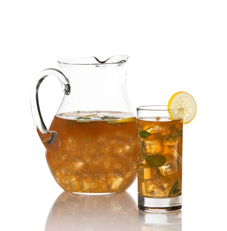 a pitcher and glass filled with tea next to each other