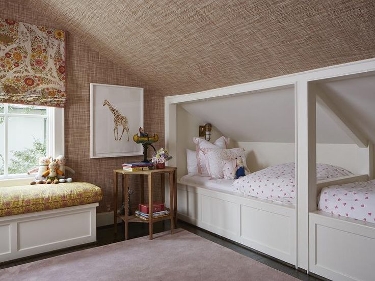 a bedroom with two twin beds and a window in the corner that has roman blinds on it