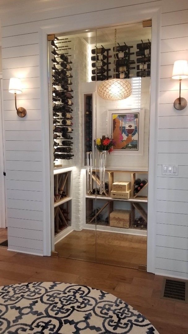 there is a room with many wine bottles on the wall and in the doorway to the kitchen