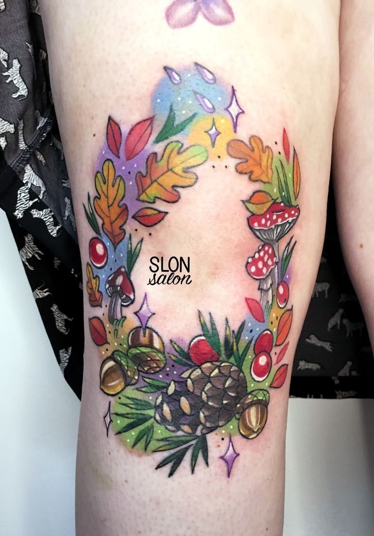 a woman's thigh with a wreath and mushrooms tattoo design on it that reads slow season