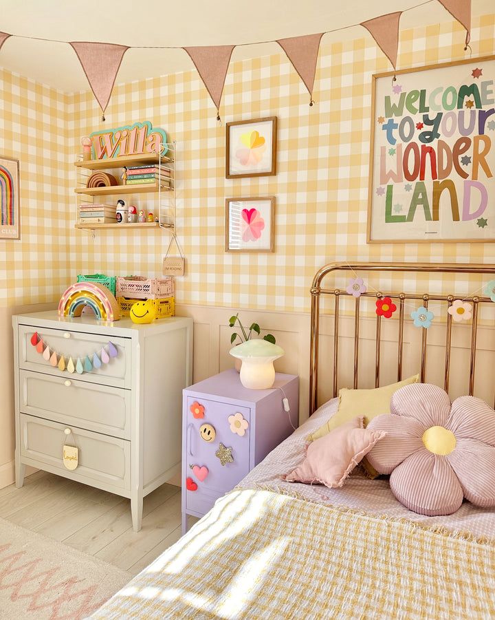 a child's bedroom decorated in pastel colors and gingham checkered wallpaper