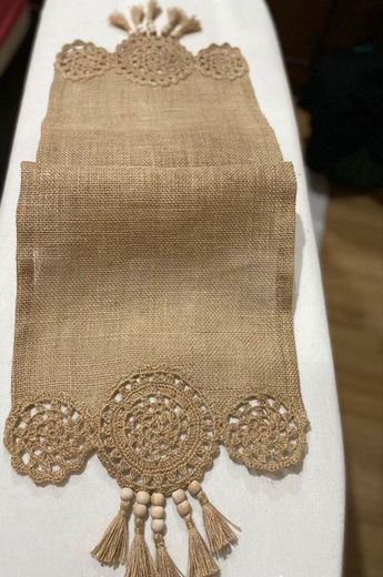 an embroidered table runner with tassels on it