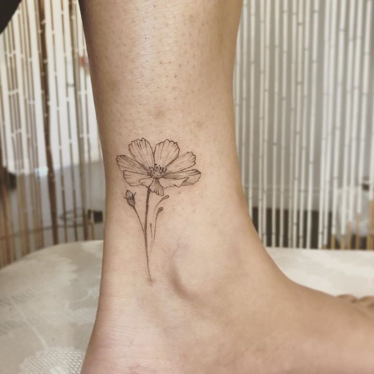 a small flower tattoo on the ankle