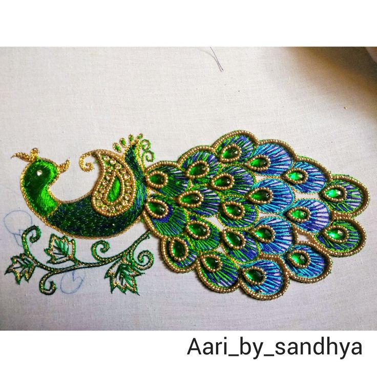 an embroidered peacock with green and blue feathers