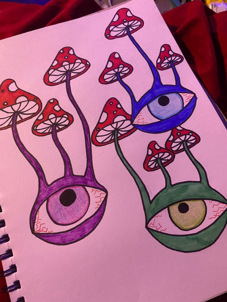 a drawing of two eyes and mushrooms on paper