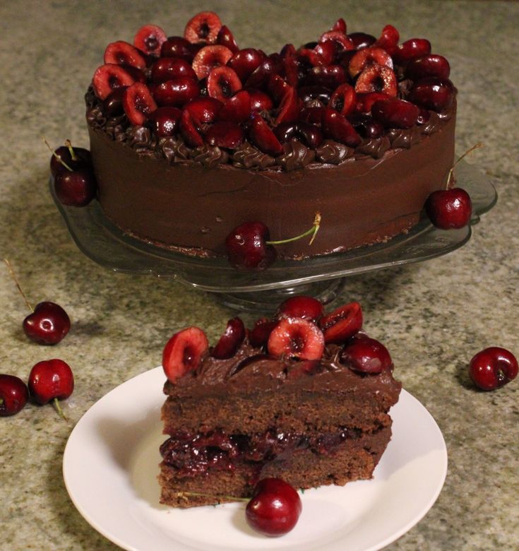 a piece of chocolate cake with cherries on the top and one slice missing from it