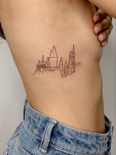 a woman with a small tattoo on her stomach that has a cityscape in the background