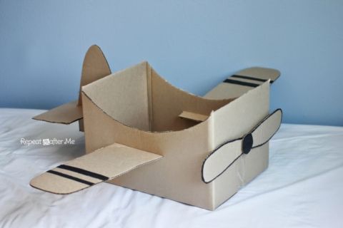 an open cardboard box that is shaped like a plane with black stripes on the sides