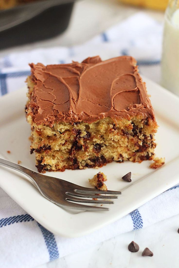 a piece of cake sitting on top of a white plate next to a glass of milk