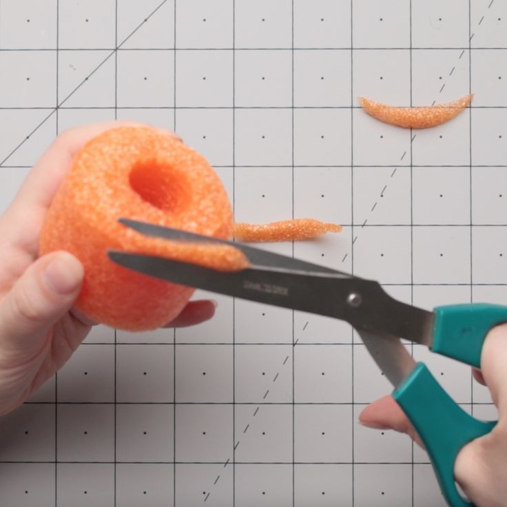 someone is cutting an orange with scissors