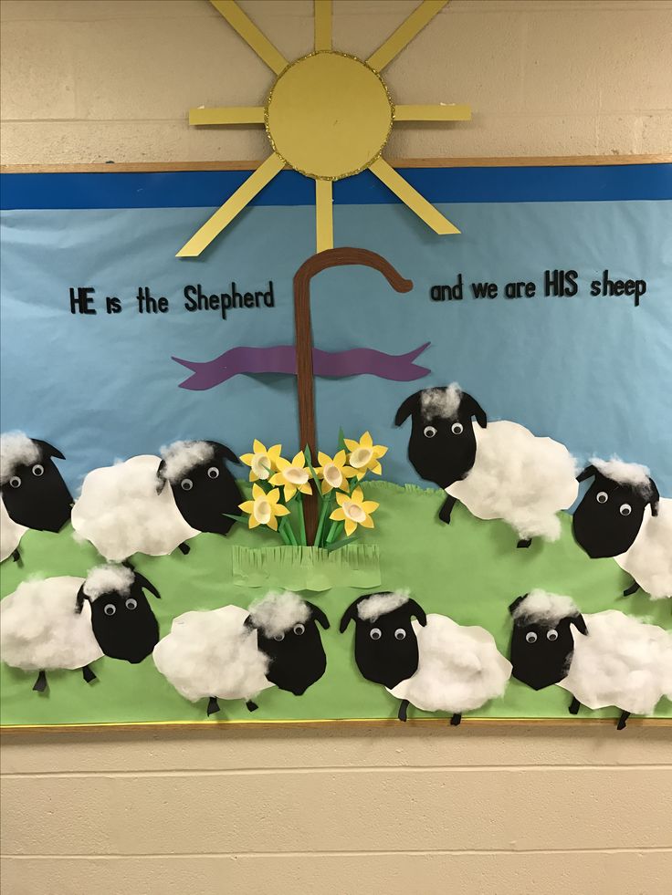 a bulletin board with sheep and daffodils in front of a sun on the wall