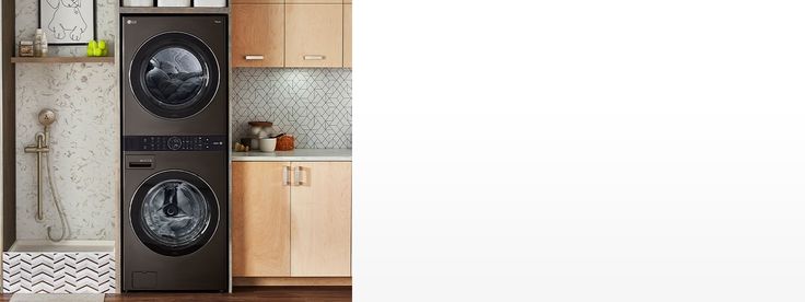 a washer and dryer in a room with wooden cabinets on the wall, next to a sink