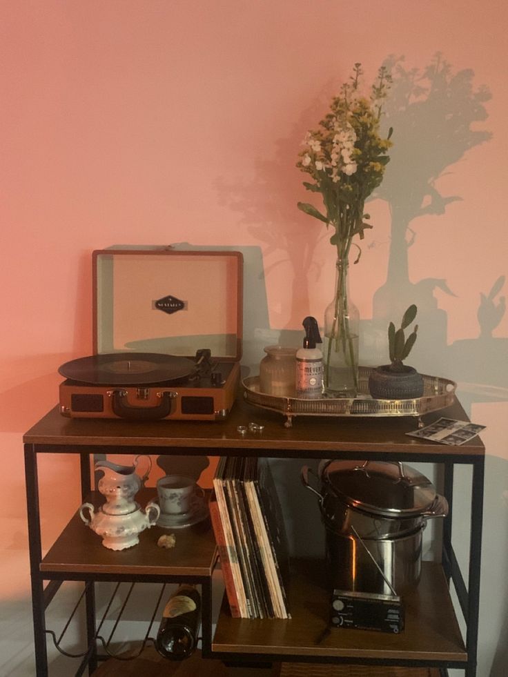 an old record player is sitting on top of a table with records and other items